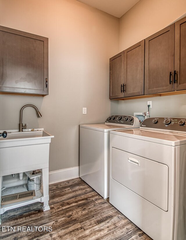 clothes washing area featuring washer and dryer, dark wood-style flooring, cabinet space, and baseboards