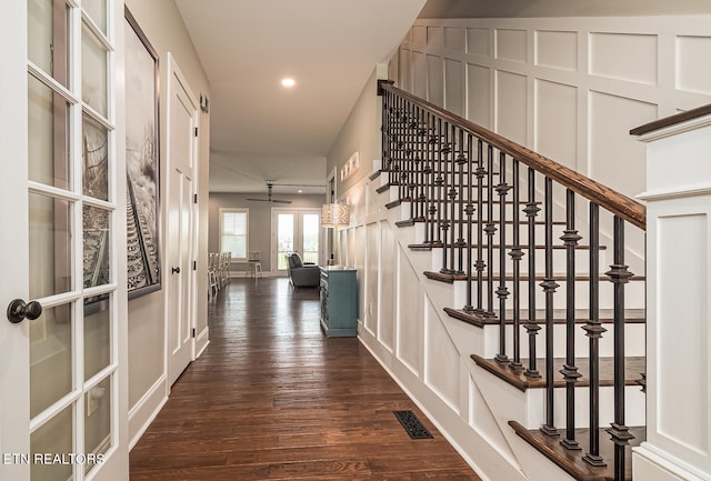 hallway featuring visible vents, dark wood-type flooring, stairs, a decorative wall, and recessed lighting