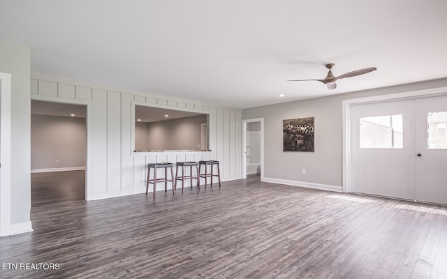 unfurnished living room featuring french doors, dark wood finished floors, a ceiling fan, and baseboards