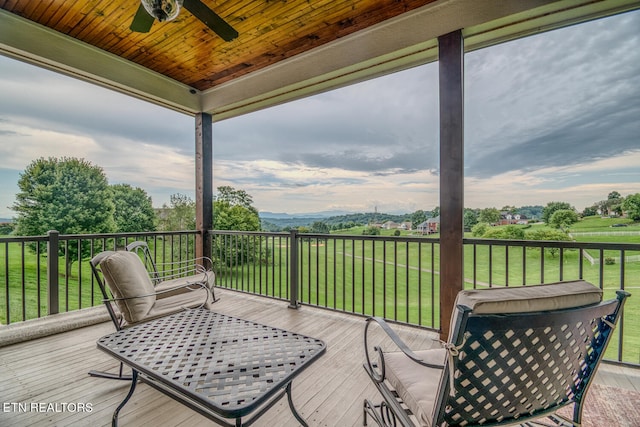 wooden terrace featuring a lawn and a ceiling fan