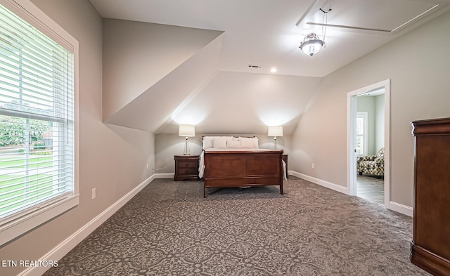 bedroom with lofted ceiling, visible vents, attic access, and baseboards