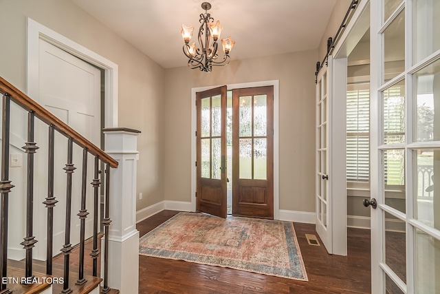 entrance foyer with stairs, french doors, dark wood finished floors, and a barn door