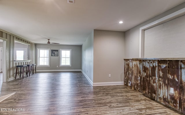 spare room with ceiling fan, visible vents, baseboards, and wood finished floors