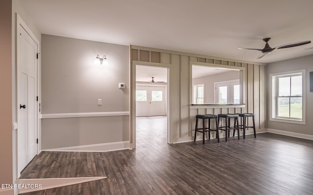 spare room featuring plenty of natural light, baseboards, and dark wood-type flooring