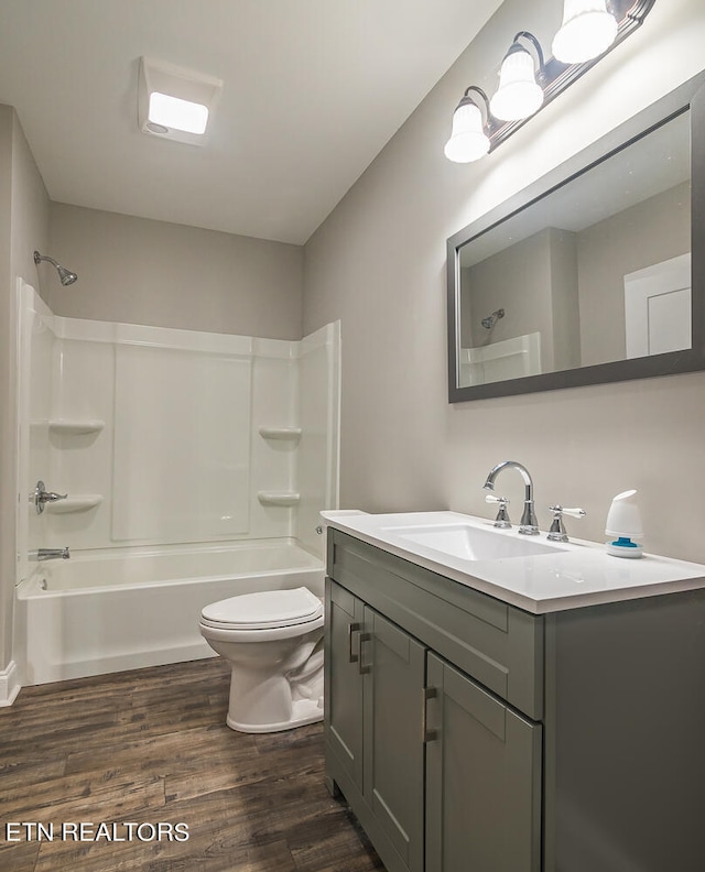 bathroom featuring vanity, shower / tub combination, wood finished floors, and toilet