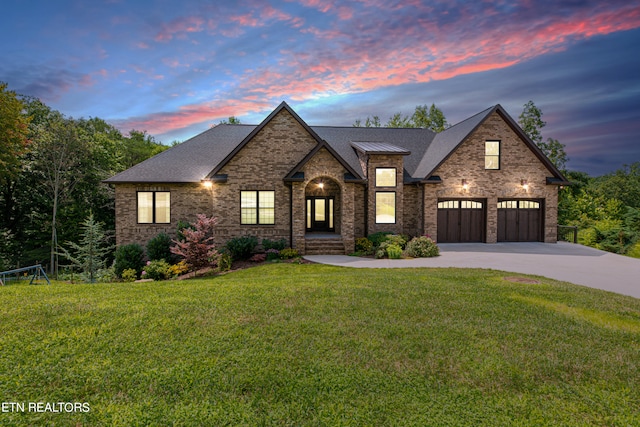 view of front of house featuring a garage and a lawn