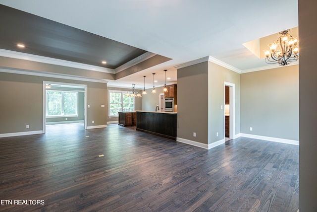 unfurnished living room with ornamental molding, hardwood / wood-style flooring, and a raised ceiling