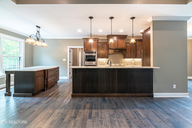 kitchen featuring pendant lighting, a spacious island, and dark wood-type flooring