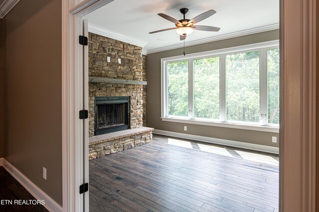 unfurnished living room featuring crown molding, a fireplace, ceiling fan, and wood-type flooring