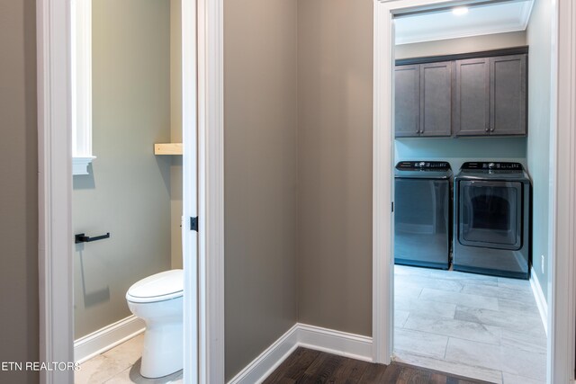 bathroom featuring toilet, washer and clothes dryer, crown molding, and hardwood / wood-style floors