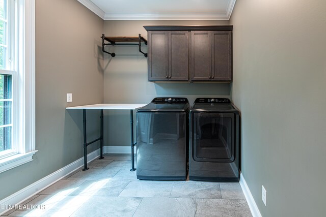 clothes washing area featuring plenty of natural light, light tile patterned flooring, cabinets, and ornamental molding