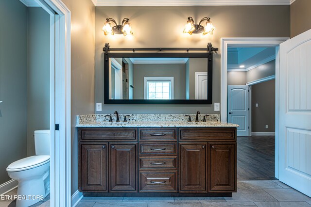 bathroom featuring double vanity, ornamental molding, hardwood / wood-style flooring, and toilet