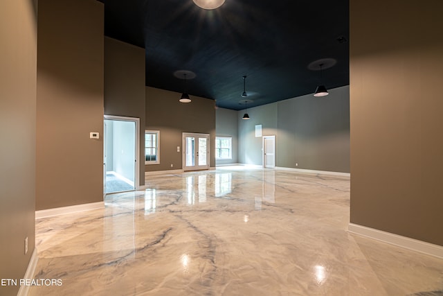 tiled spare room with a high ceiling