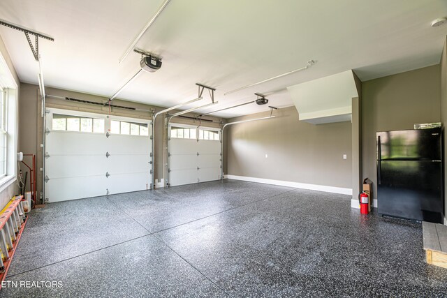 garage with black fridge and a garage door opener