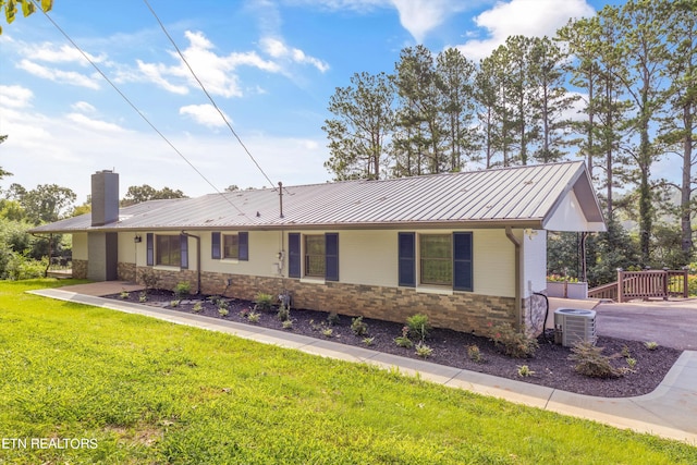 view of front of home featuring central AC and a front lawn