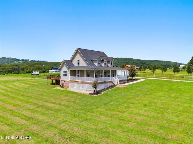 back of house featuring a deck and a lawn