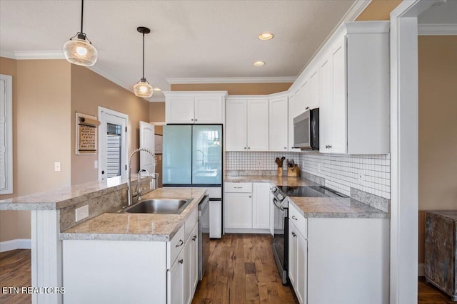 kitchen featuring appliances with stainless steel finishes, tasteful backsplash, sink, pendant lighting, and dark hardwood / wood-style flooring