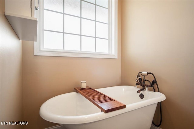 bathroom featuring a bathing tub and a wealth of natural light