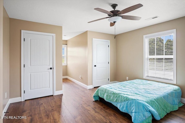 bedroom with multiple windows, hardwood / wood-style floors, and ceiling fan