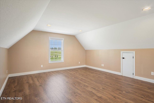 additional living space featuring hardwood / wood-style flooring and vaulted ceiling