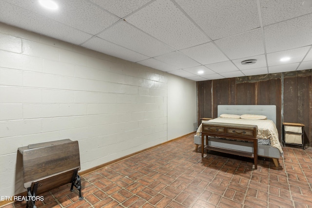 bedroom with a paneled ceiling and wooden walls