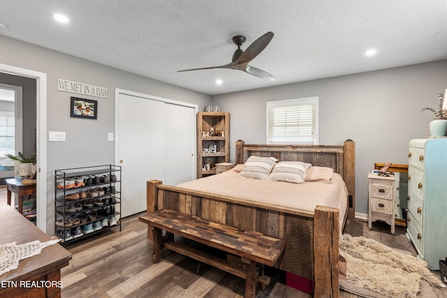 bedroom featuring a closet, a textured ceiling, hardwood / wood-style floors, and ceiling fan