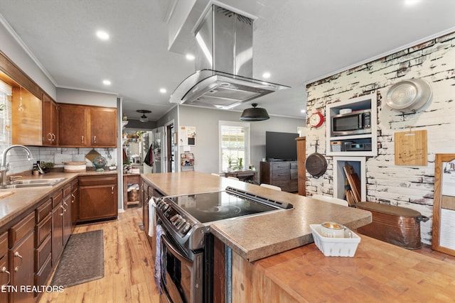 kitchen with tasteful backsplash, light wood-type flooring, sink, island exhaust hood, and appliances with stainless steel finishes