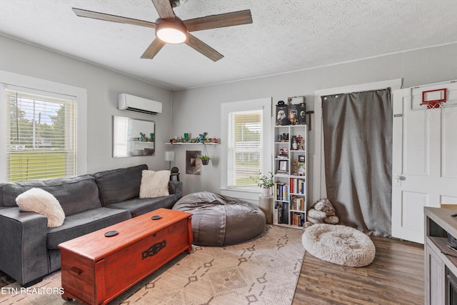 living room with a healthy amount of sunlight, light hardwood / wood-style floors, a textured ceiling, and ceiling fan