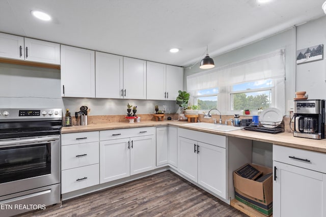 kitchen featuring sink, stainless steel range with electric stovetop, dark hardwood / wood-style flooring, and white cabinetry