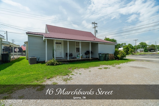 view of front of house featuring a front lawn, covered porch, and central AC unit