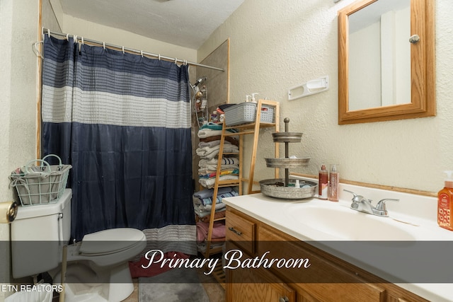 bathroom with vanity, a textured ceiling, and toilet