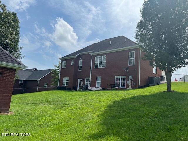 back of house with a lawn and cooling unit