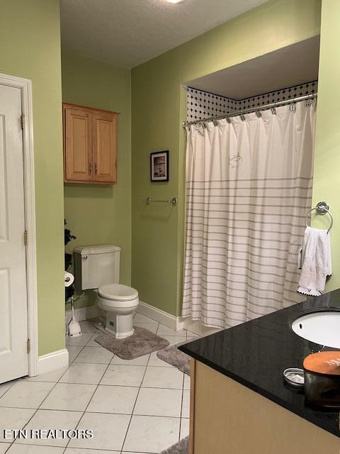 bathroom with tile patterned floors, toilet, curtained shower, and vanity