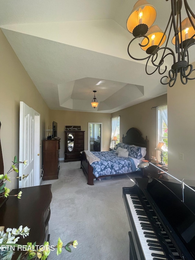 bedroom featuring a tray ceiling, a notable chandelier, and carpet