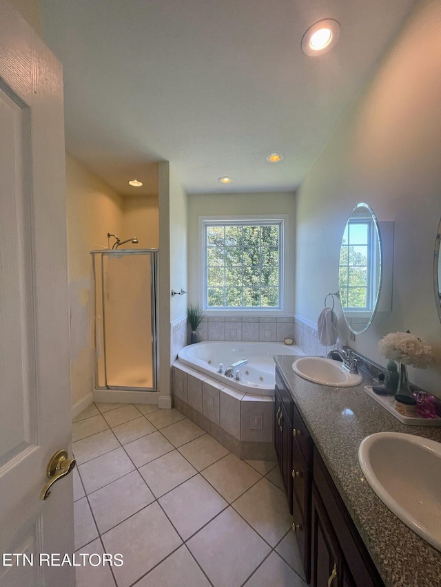 bathroom featuring tile patterned flooring, shower with separate bathtub, and vanity