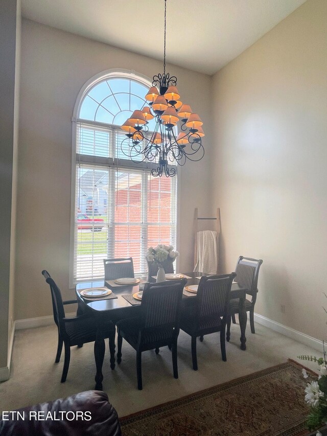 dining space featuring vaulted ceiling, a notable chandelier, and carpet