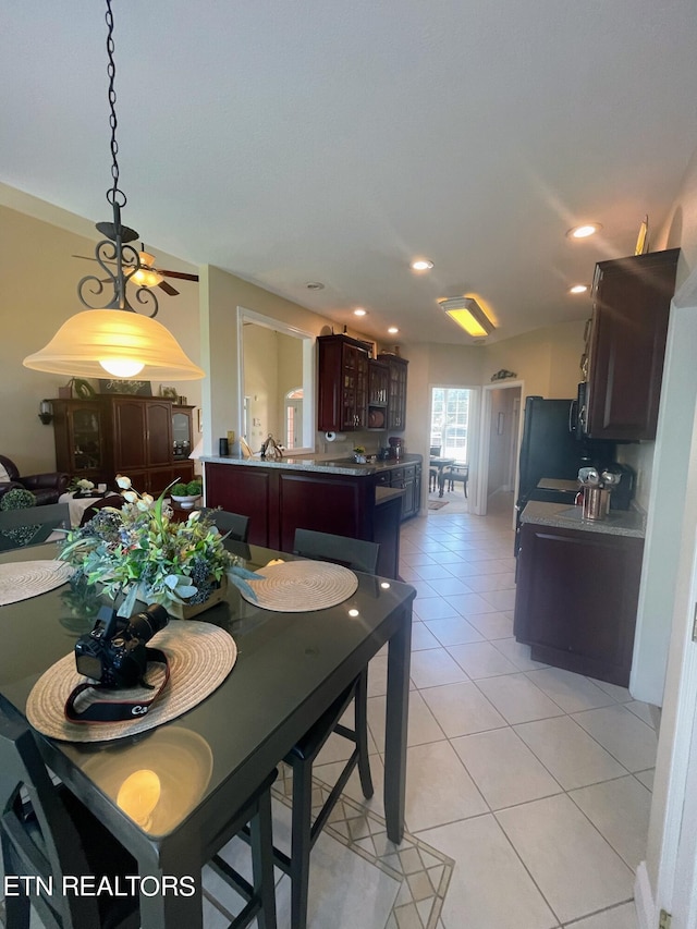 tiled dining area with ceiling fan