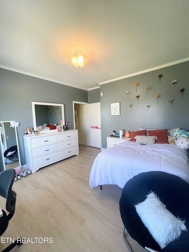 bedroom featuring light wood-type flooring, a textured ceiling, and ornamental molding