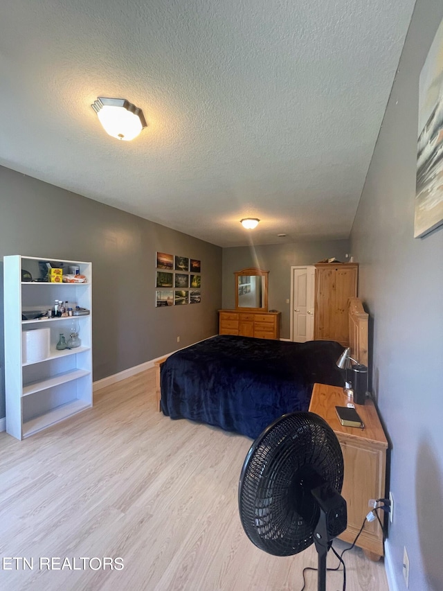 bedroom with a textured ceiling and wood-type flooring