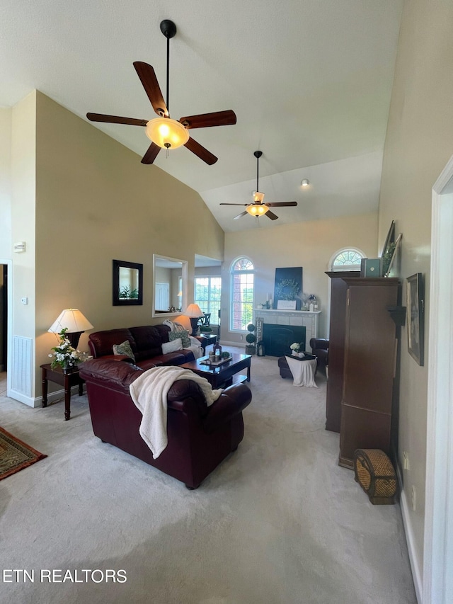 living room with carpet, ceiling fan, high vaulted ceiling, and a fireplace