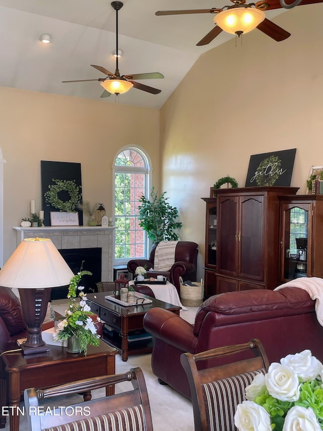 carpeted living room featuring lofted ceiling, ceiling fan, and a tile fireplace