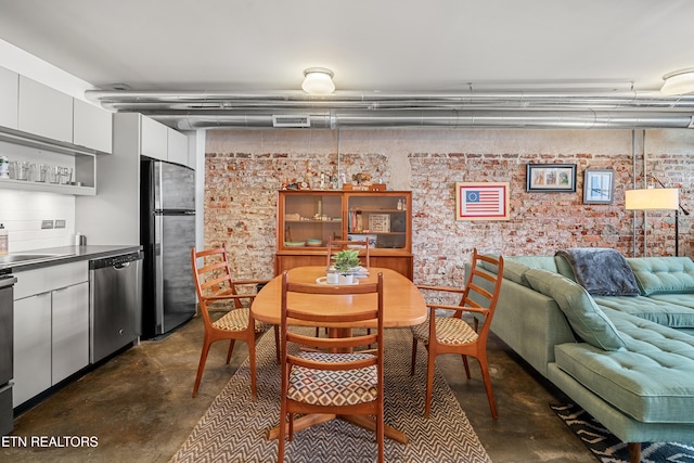 dining room featuring brick wall