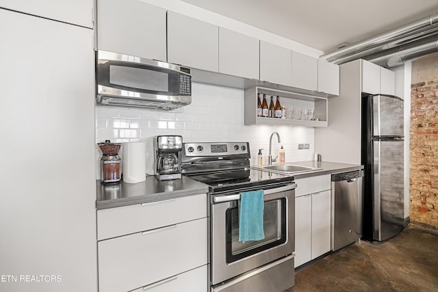 kitchen featuring appliances with stainless steel finishes, white cabinets, sink, and backsplash