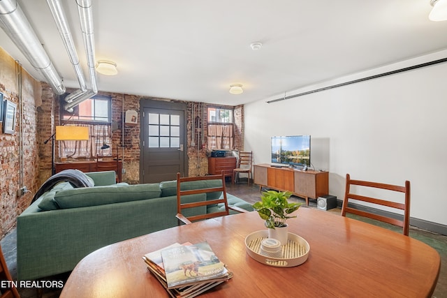 dining area featuring brick wall and plenty of natural light