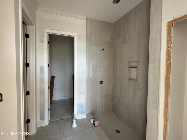 bathroom featuring a tile shower, crown molding, and tile patterned flooring