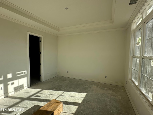 empty room featuring ornamental molding and a tray ceiling