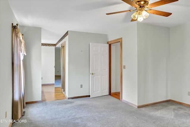 empty room with ceiling fan and light carpet