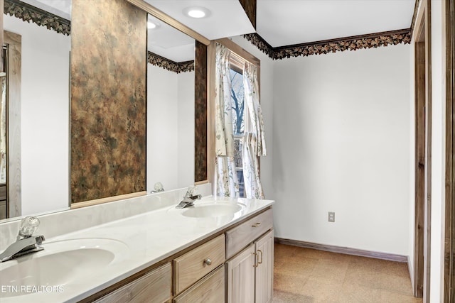 full bathroom featuring a sink, baseboards, double vanity, and tile patterned floors