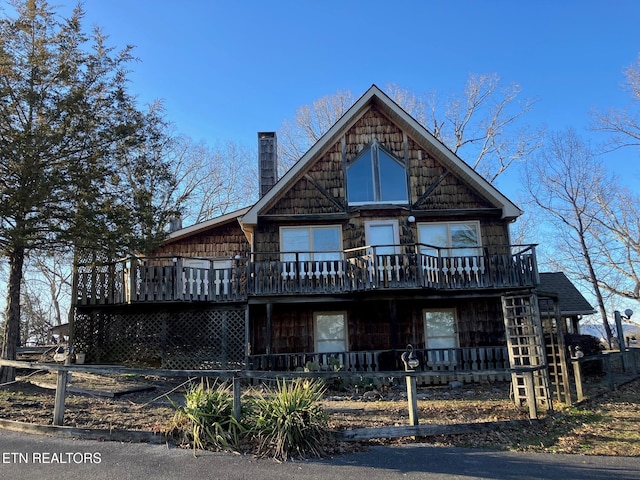 chalet / cabin featuring covered porch and a chimney