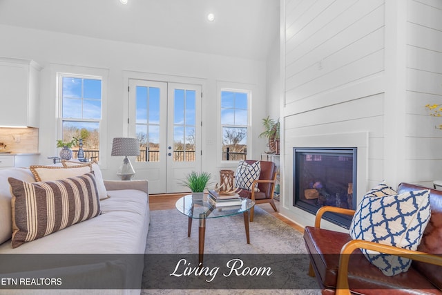 living room with lofted ceiling, french doors, and hardwood / wood-style flooring